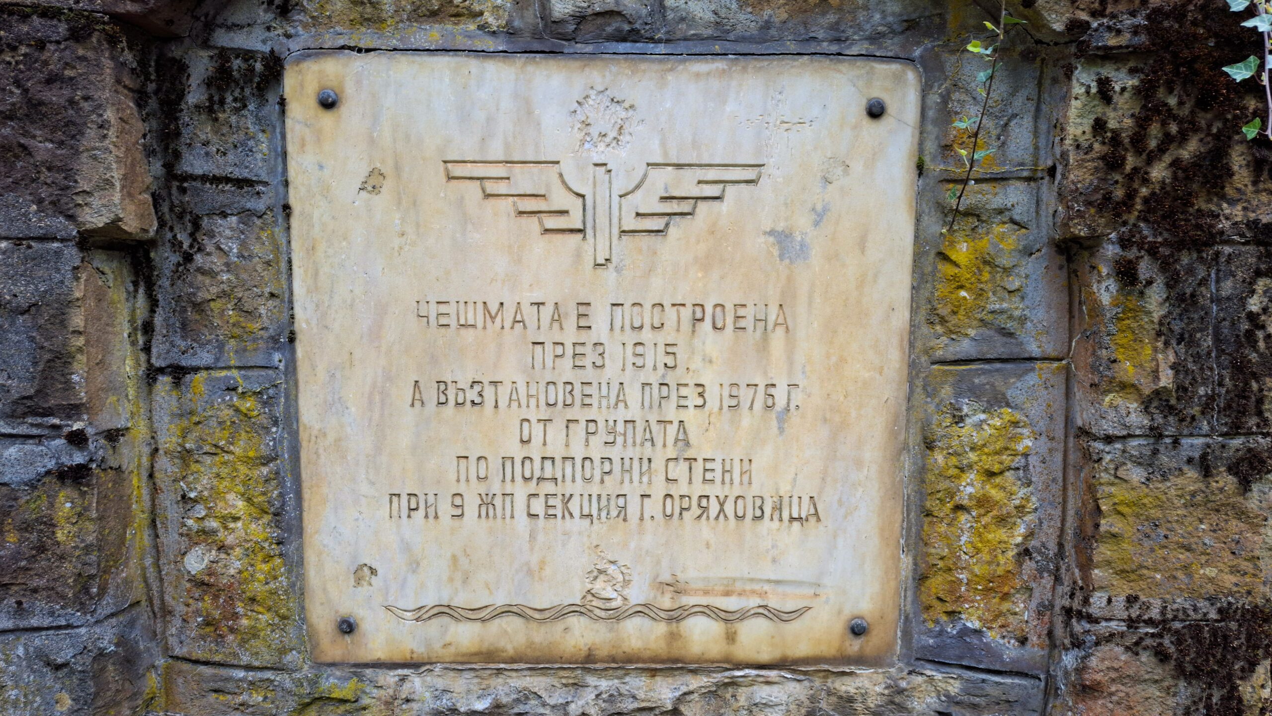 Плочата на чешмата с логото на БДЖ, надписа и заличените символи