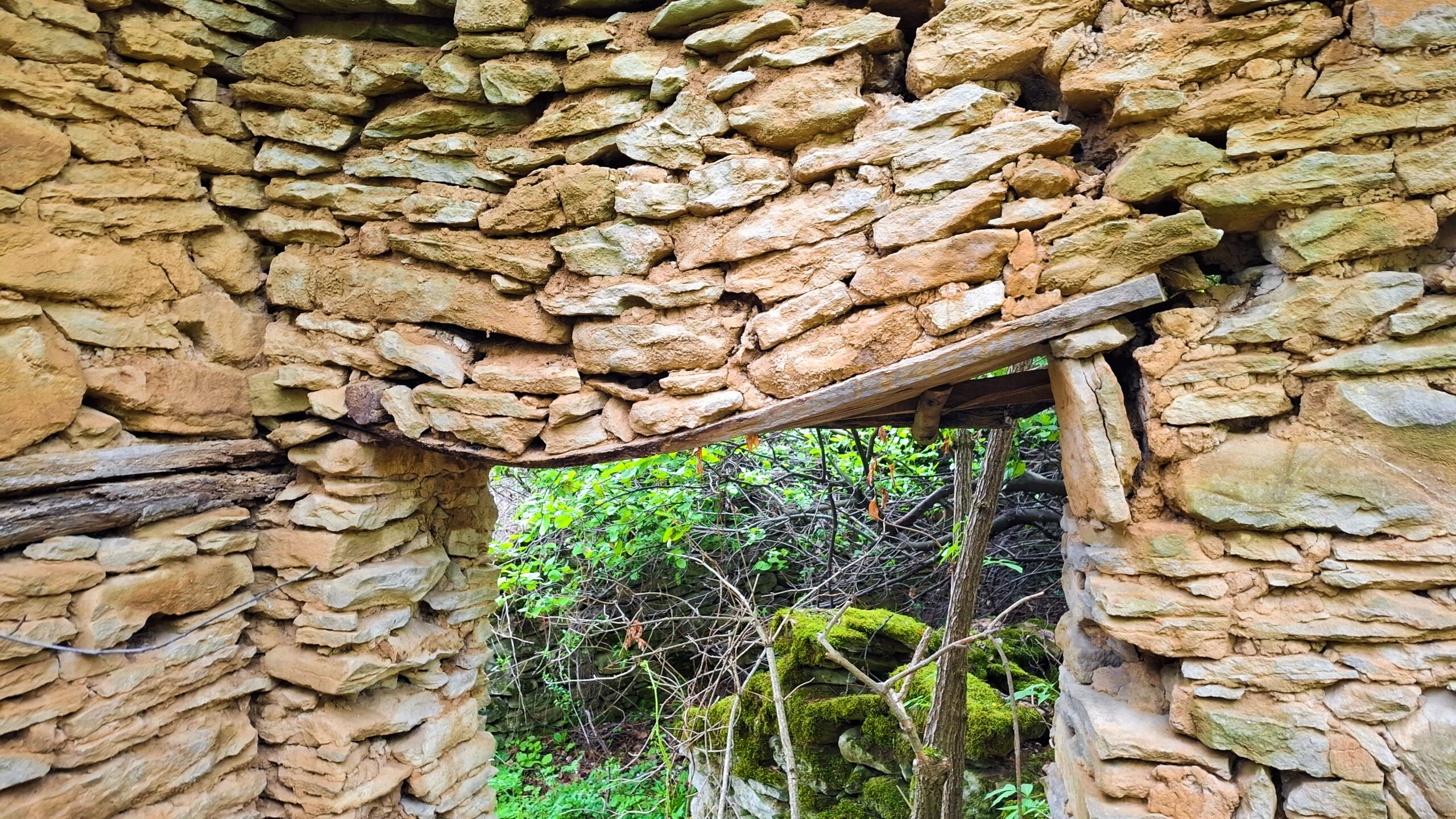 Дървената дъска, огънала се до неузнаваемост, но устояваща на тежестта на зида